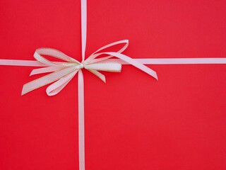 A white bow on a red background.