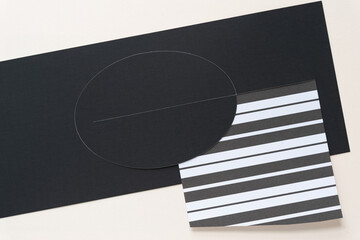 black paper with oval and paper with stripes