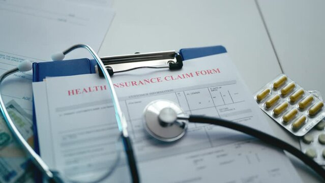 Detail shot of health insurance form with stethoscope and money, pharmaceuticals