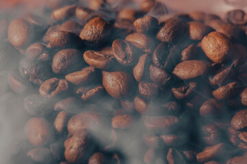  Roasted coffee beans with smoke and fire background. Close up,