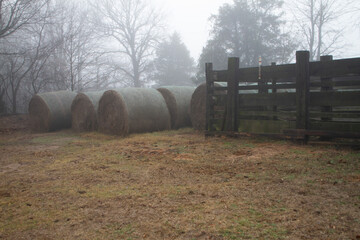 Hay stored for winter feeding on a small farm next to wooden corral