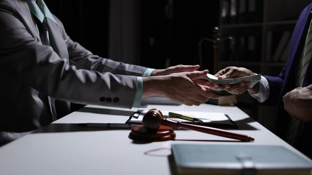 Corrupt lawyer accepts bribes from an unknown man in the dark. Businessman in the dark tries to bribe officials.