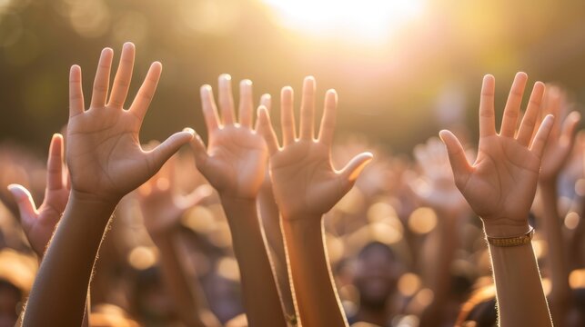 A group of people raising their hands in the air