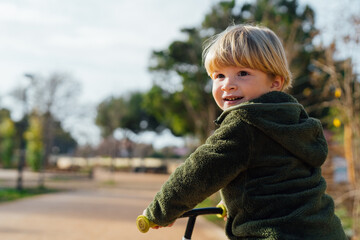 Fototapeta premium A little boy is on a bike ride.3 year old blond boy plays and enjoys a sunny day in the park on a bicycle