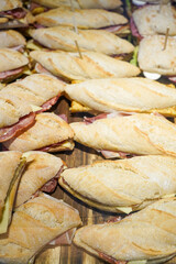 Assorted sandwiches neatly arranged on a wooden surface.