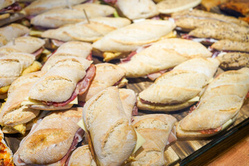 Ham and cheese sandwiches on crusty baguettes arranged on a platter.