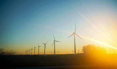 Wind turbines against a sunrise sky, symbolizing renewable energy.