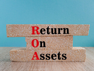 ROA- return on assets symbol. Brick blocks with the inscription return on assets on beautiful blue...