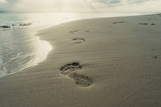 Waves washing on footprints in the white sand of San Blas islands in Panama