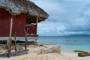 Caribbean sea view with blue water next to red beach hut at Panama coast