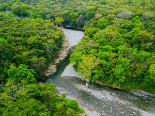 Fototapeta na wymiar Drone view of small jungle river with washed up stones in an intact natural environment of Panama