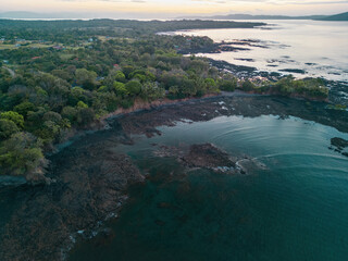 High altitude drone view of rocky beach during low tide in Santa Catalina during sunset