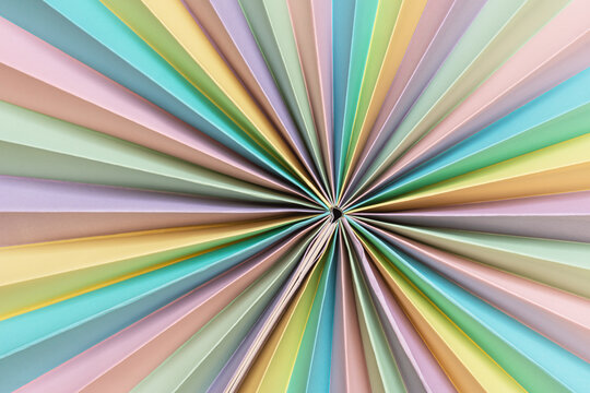 Colorful decorative paper rosette. Circle shaped folded paper. Pastel color paper with radial folds - Powered by Adobe