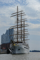 Luxury sailing yacht windjammer cruiseship cruise ship liner Spirit sail away under full sails from Hamburg, Germany on River Elbe during breathtaking sunset