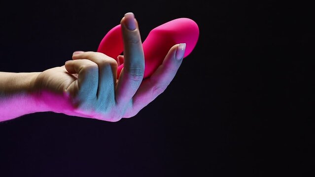 In the hands of a young girl vibro toy for sexual pleasures. The girl is holding a sex shop toy Sex toy clitoral vibrator