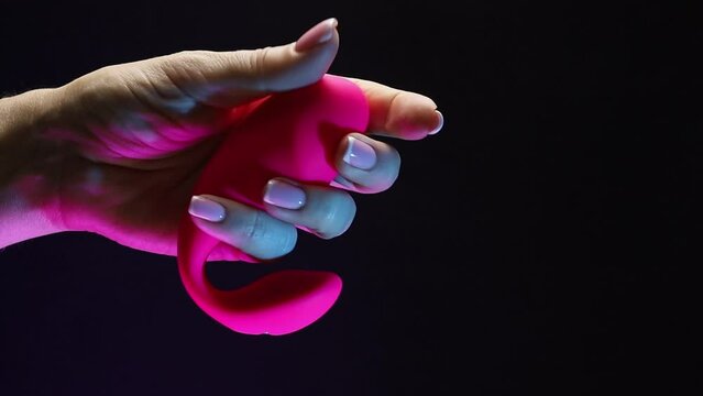 In the hands of a young girl vibro toy for sexual pleasures. The girl is holding a sex shop toy Sex toy clitoral vibrator