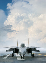F-14 jet fighter on an aircraft carrier deck beneath dramatic clouds viewed from front
