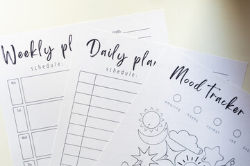 Planner and mood tracker printed on a paper and placed on the table.