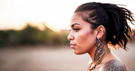 Fotobehang primo piano testa di giovane donna latino americana, vista di profilo, tatuaggi e capelli corvini © divgradcurl
