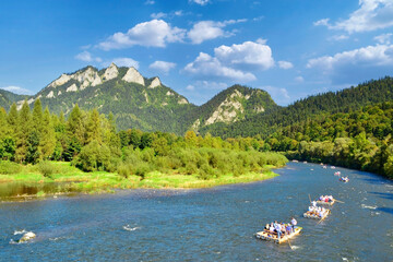 Fototapeta na wymiar Rafting on the Dunajec river with view on Three Crowns in the Pieniny National Park in summer sunny day. It is a popular tourist attraction in Pieniny mountains, Poland.