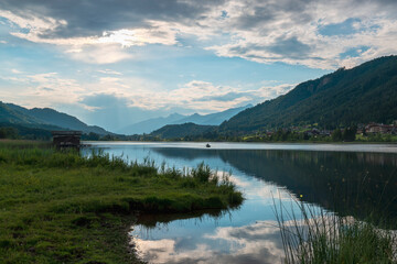 Fototapeta na wymiar Calm alpine lake with sky reflection at the sunset.