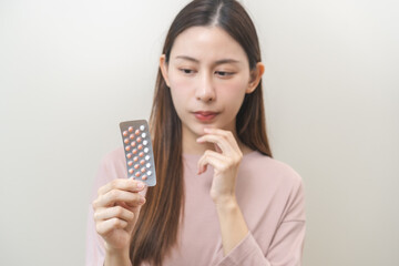 Contraception and pregnancy, menstruation concept, birth control pills asian young woman hand...