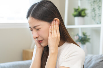 Tinnitus concept, sick asian young woman, girl have ear pain or earache, hand touch plug ear, suffering painful otitis from loud of noisy sound, inflammation. Health care nerve deaf eardrum disease. - obrazy, fototapety, plakaty