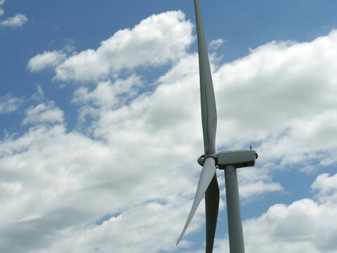 An image of wind turbine generator on a cloudy sky background