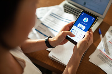 Woman using smartphone to conduct online mobile banking