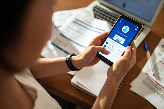 Woman using smartphone to conduct online mobile banking