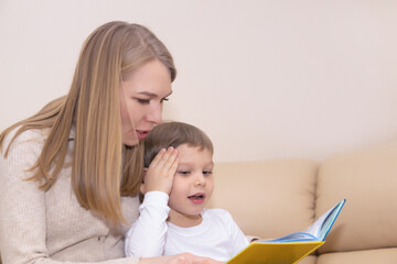 woman reading book to child indoors