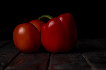Red pepper and tomatoes on a black background