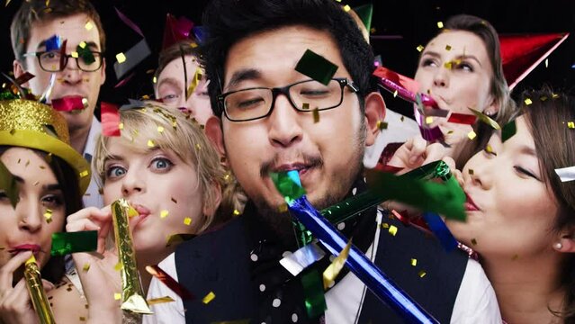 Party, blower and group in celebration with confetti and happiness at event in slow motion. Happy, surprise and portrait of people with whistle, cheering and excited friends in social community