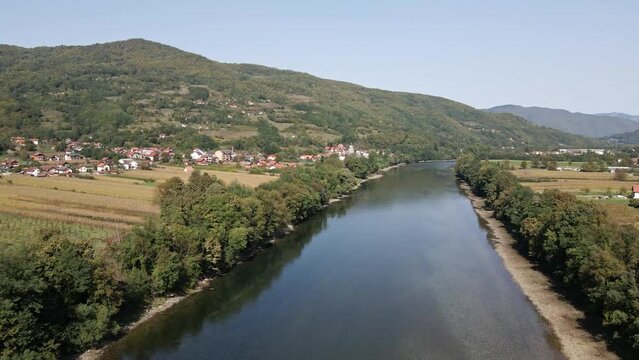 Drone captures Drina river in a valley of mountains near town Bajina Basta