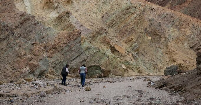 Death Valley women rockhounding narrow slot canyon. Largest national park in contiguous USA. 282 feet below sea level. Mojave Desert bordering Great Basin Desert. Ecological geology. 