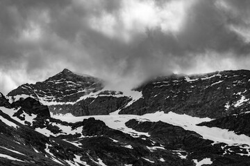 Swiss Alps, beautiful black and white mountains travel view in the snow with moody cloudscape