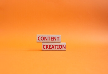 Content creation symbol. Concept word Content creation on wooden blocks. Businessman hand. Beautiful orange background. Business and Content creation concept. Copy space