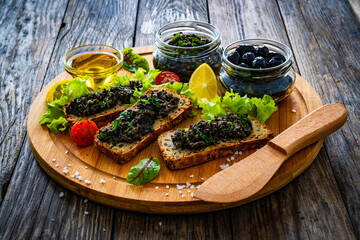 Tasty bruschetta with tapenade on wooden table
