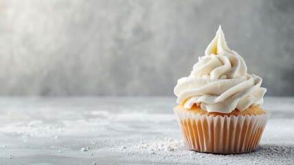 Single vanilla cupcake with creamy white icing and sugar dust - obrazy, fototapety, plakaty
