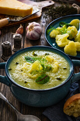 Cauliflower cream soup on wooden table
