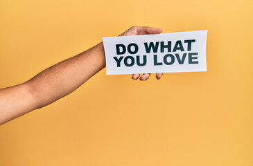 Hand of caucasian man holding paper with do what you love message over isolated white background
