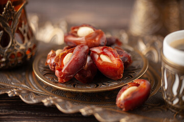 Cup of coffee and glass of tea and dry dates stuffed almonds on saucer ready to eat for iftar time....