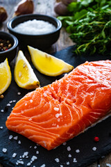 Fresh raw salmon steak with fresh vegetables on wooden background

