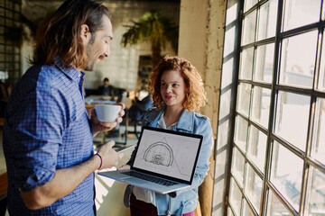 Young colleagues discussing architectural plans in the office
