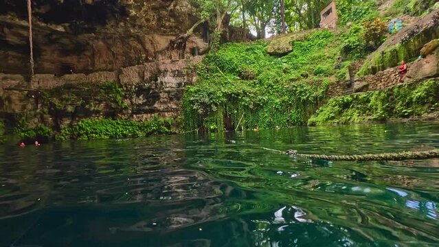 Cenote semi descubierto en la ciudad de Valladolid en Quintana roo, caribe mexicano cuevas y rios subterraneos con agua turquesa