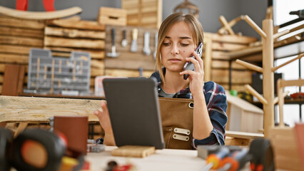 The charming young blonde carpenter adroitly multitasks between her touchpad and smartphone...