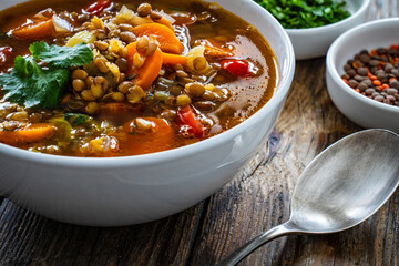 Fresh vegetable soup with lentil on wooden table

