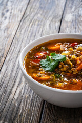 Fresh vegetable soup with lentil on wooden table

