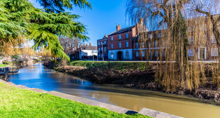 A view beside the Church Street bridge across the River Welland in the centre of Spalding, Lincolnshire on a bright sunny day - obrazy, fototapety, plakaty