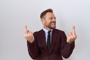 Middle age business man with beard wearing suit and tie showing middle finger doing fuck you bad expression, provocation and rude attitude. screaming excited